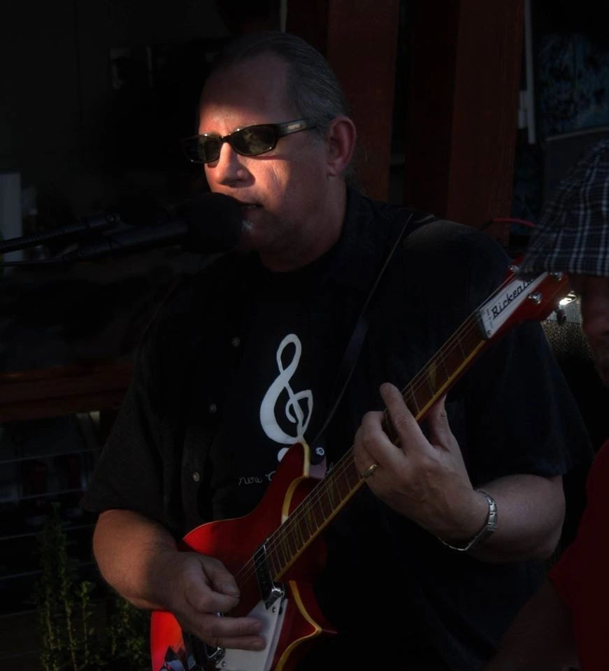 Dr. D performing with guitar and sunglasses