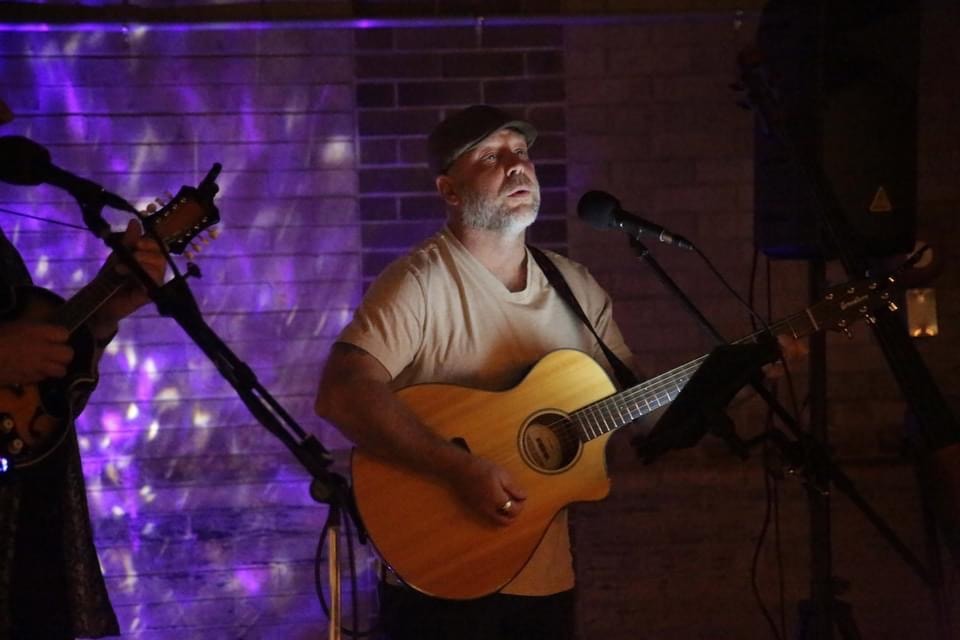 Dr. D performing acoustic guitar live