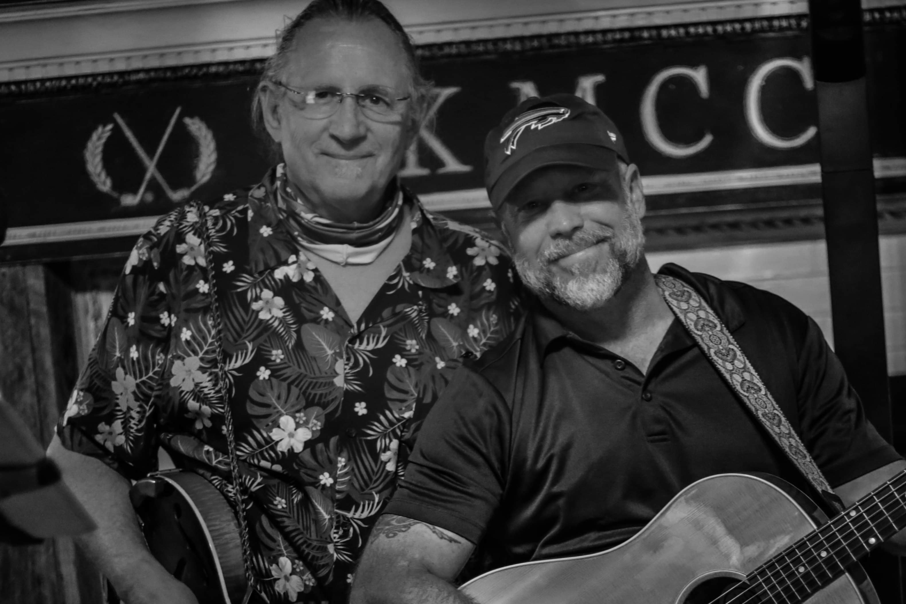 Two musicians posing with acoustic guitar